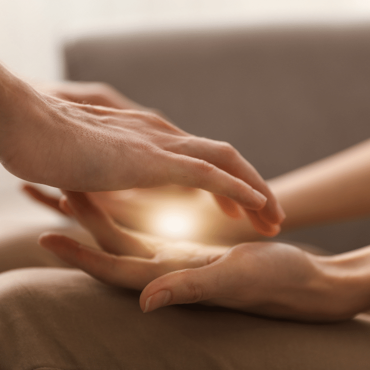 Hands held above a recipient during an energy-healing session