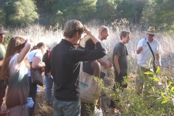 John Finch leading a group on a herb identification walk in a San Diego canyon.