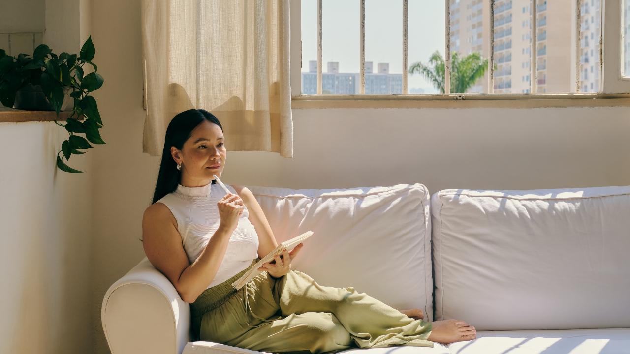A woman resting with a book in a bright, peaceful room